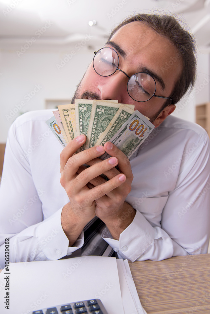 Young male bookkeeper in budget planning concept Young male bookkeeper in budget planning concept