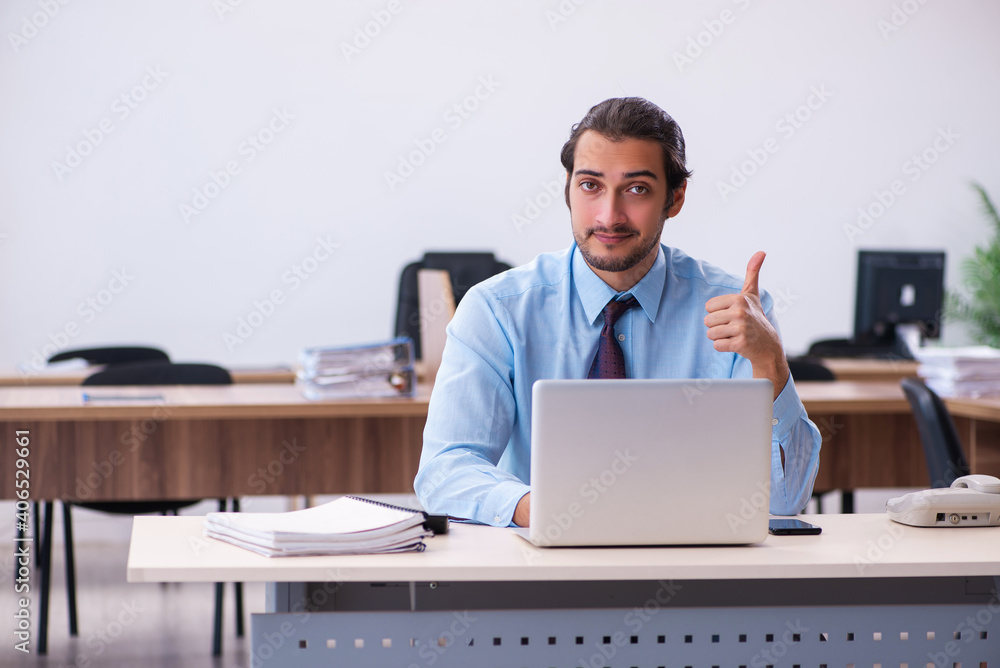 Young male employee working in the office Young male employee working in the office