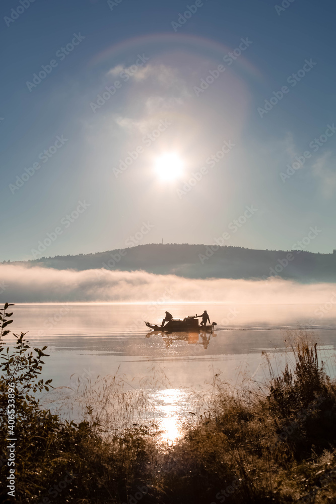 Fishing boats on the lake in the morning. Morning mist. Copy space Fishing boats on the lake in the morning. Morning mist. Copy space