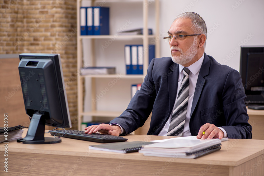 Aged businessman employee sitting in the office Aged businessman employee sitting in the office