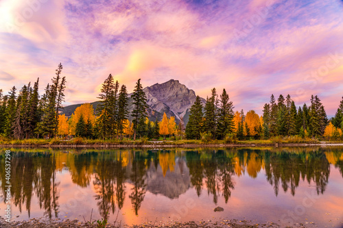 Banff National Park beautiful natural scenery at dawn in autumn foliage season. Fiery pink clouds, Cascade Mountain and colorful yellow and green trees reflected on Bow River. Canadian Rockies.  © Shawn.ccf