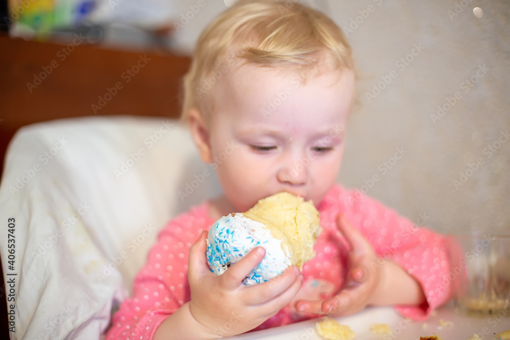 little girl eats an Easter cake cooked by mom. small paska in hands of child at Orthodox Easter in Ukraine. traditional babka. cake for celebration. easter concept little girl eats an Easter cake cooked by mom. small paska in hands of child at Orthodox Easter in Ukraine. traditional babka. cake for celebration. easter concept