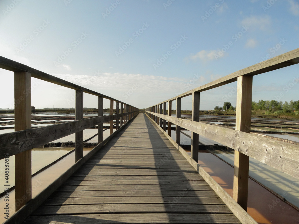 Wooden bridge over water and salt flats in beautiful summer day, in aveiro, portugal