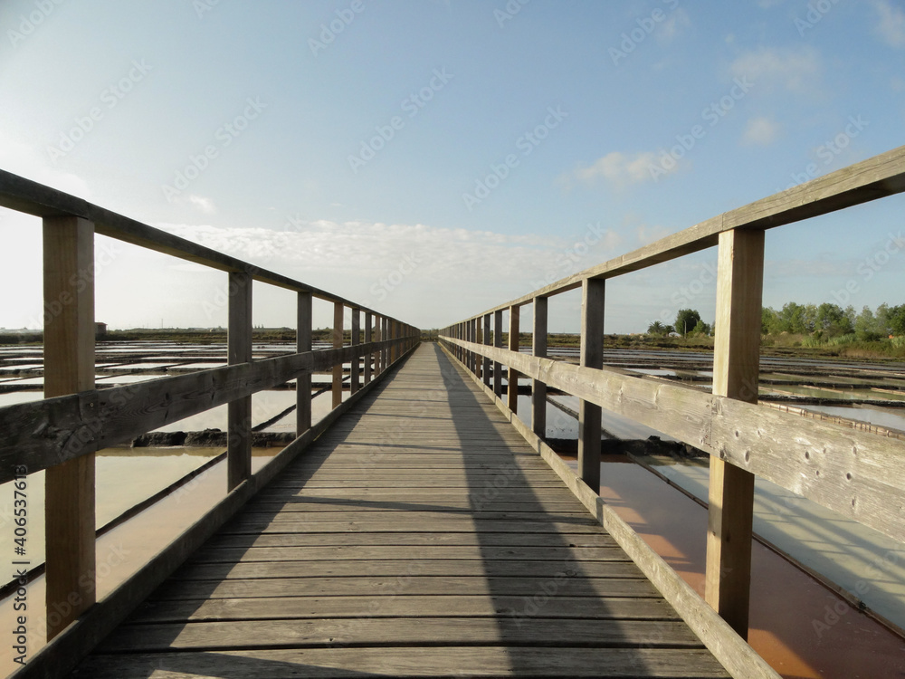 Wooden bridge over water and salt flats in beautiful summer day, in aveiro, portugal Wooden bridge over water and salt flats in beautiful summer day, in aveiro, portugal