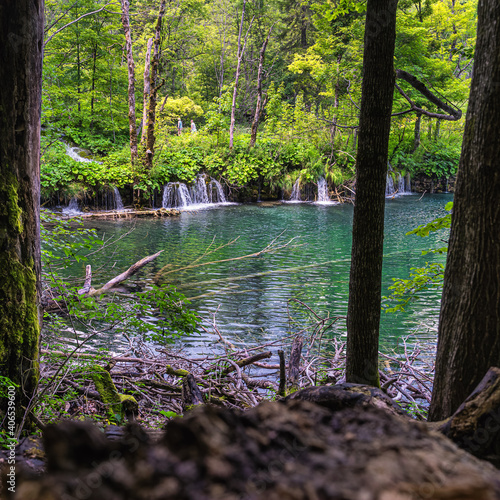 Couple of tourists sightseeing beautiful waterfalls  lakes and green lush forest in Plitvice Lakes National Park UNESCO World Heritage  Croatia