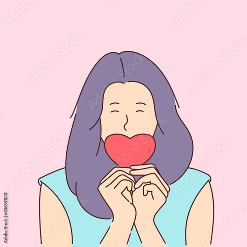 Love story or Valentines day concept. Young smiling girl covers her mouth with a paper red heart.