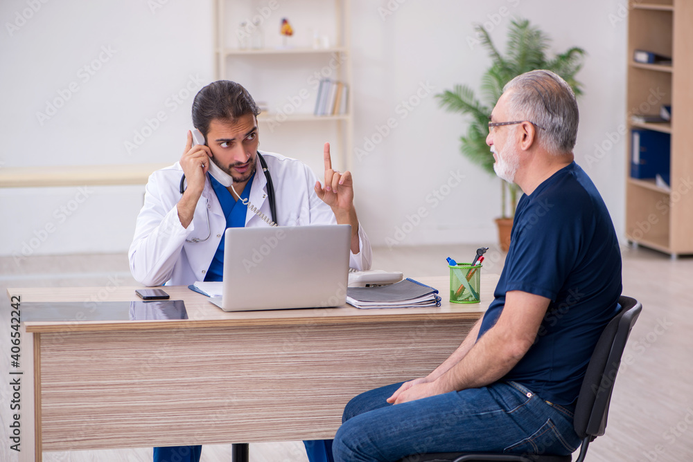 Old male patient visiting young male doctor Old male patient visiting young male doctor