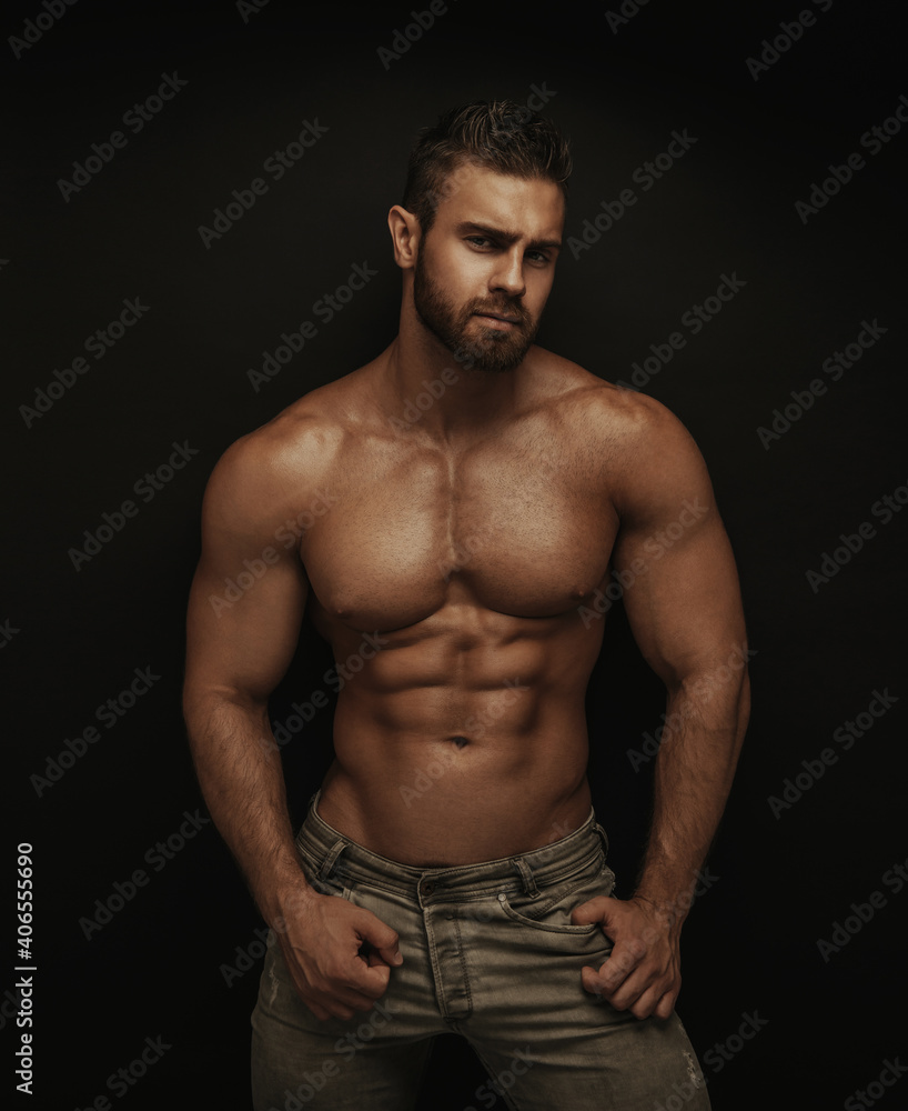 Fototapeta premium Fitness male model standing on dark background