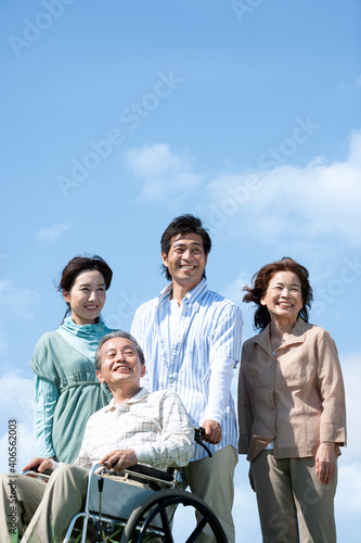車椅子に座るシニア男性と笑顔の家族