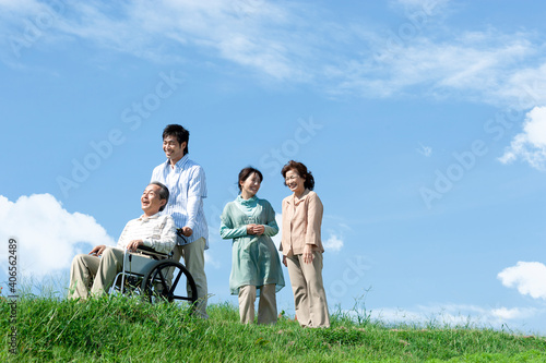 車椅子に座るシニア男性と笑顔の家族