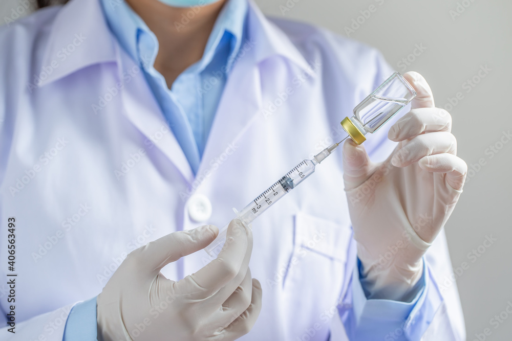 Doctor or scientist filling a syringe with medication in the laboratory holding a syringe with liquid vaccines. Vaccination and immunization. close up. Doctor or scientist filling a syringe with medication in the laboratory holding a syringe with liquid vaccines. Vaccination and immunization. close up.