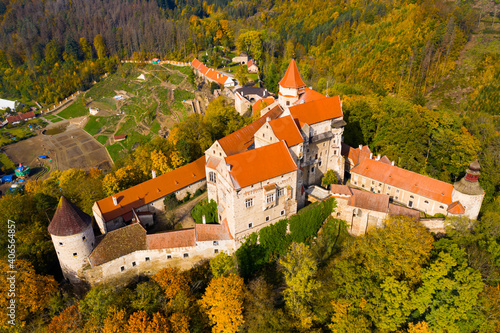 View from drone of autumn landscape overlooking ancient Pernstejn castle on hilltop between forests, Nedvedice, Czech Republic photo