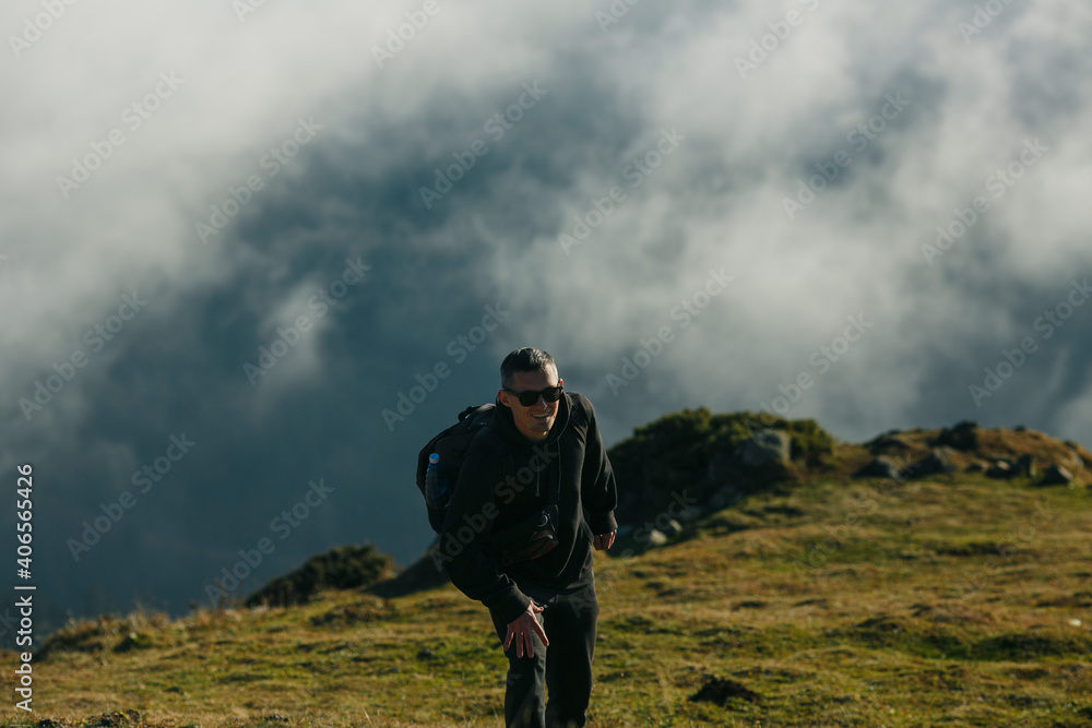 Man in the mountains against the background of clouds.