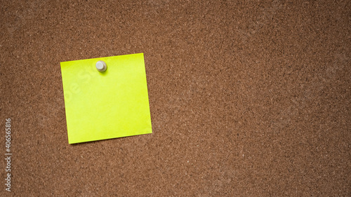 yellow note tacked to a corkboard 