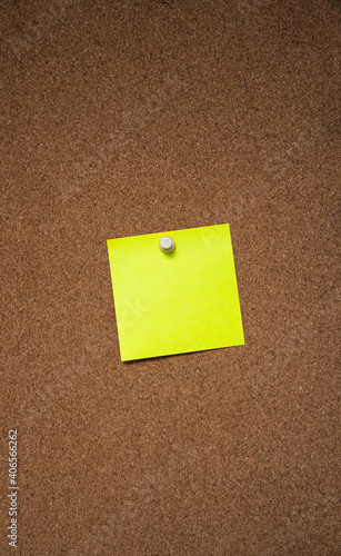 yellow note tacked to a corkboard 