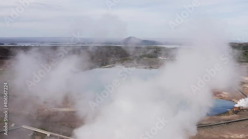 Flying through steam from geothermal powerplant Bjarnarflag with blue lake photo