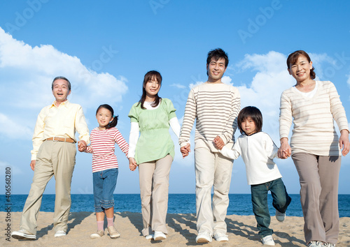 砂浜を歩く三世代家族