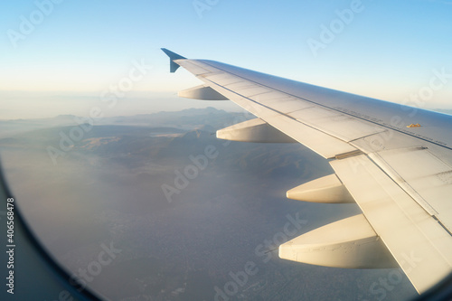 ventanilla de avion, alas y niebla en la mañana sobre mexico
