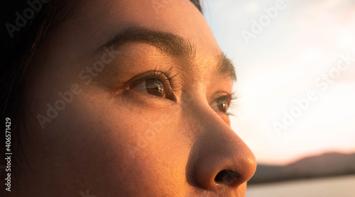Valokuva Side view of happy hopeful woman looking away to nature reflection on water at sunset lakeside