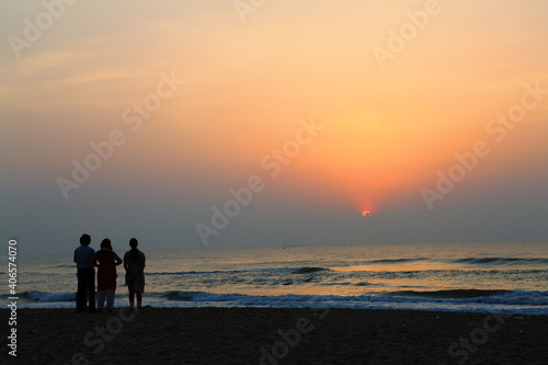 group of people on the beach in sunset.