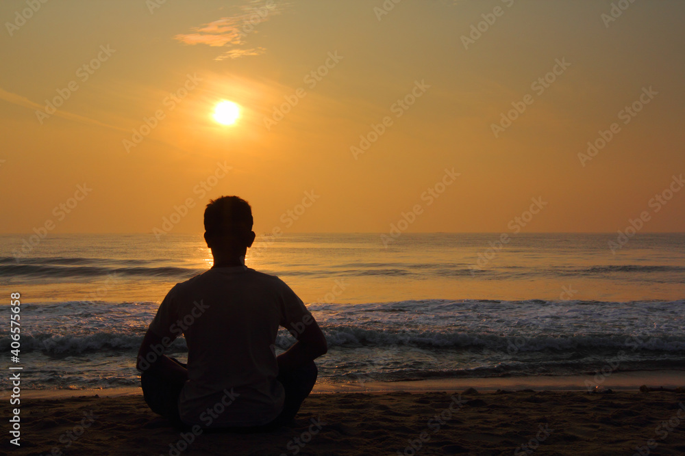 silhouette of person sitting on the beach