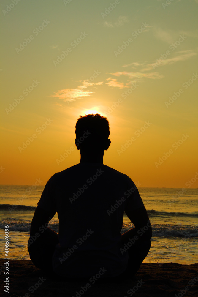 silhouette of person sitting on the beach