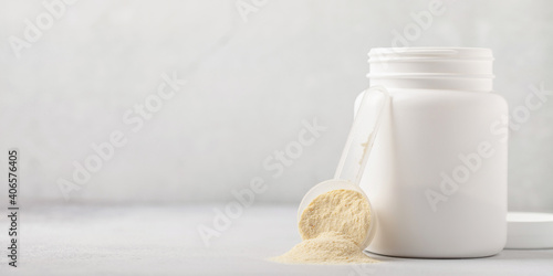 Canvas Print Whey protein powder in measuring scoop and jar  on grey background