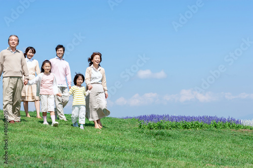 芝生を歩く三世代家族