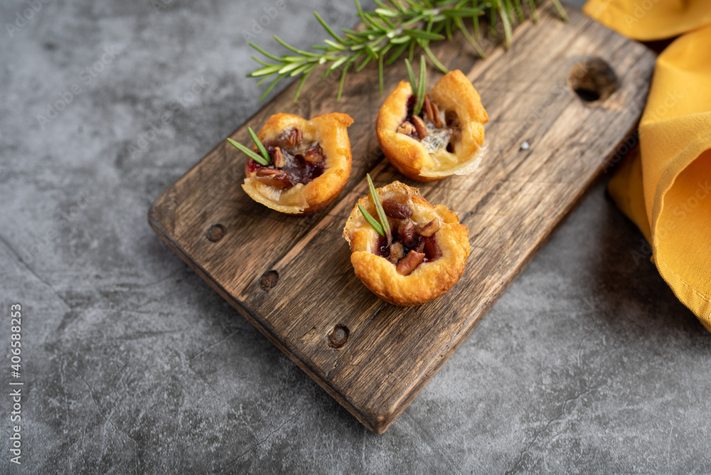 Fototapeta premium Brie bites with jam and nuts in crescent dough, mini appetizer dessert with cranberry or any jelly
