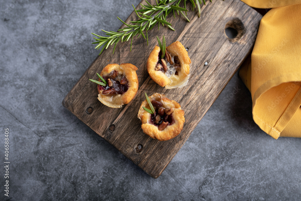 Fototapeta premium Brie bites with jam and nuts in crescent dough, mini appetizer dessert with cranberry or any jelly