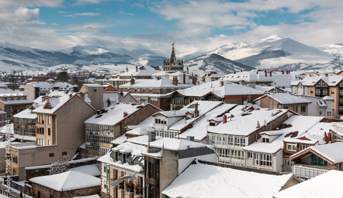 Paisaje nevado de la ciudad de Reinosa con los tejados de sus edificios blancos y las montañas cubiertas al fondo photo