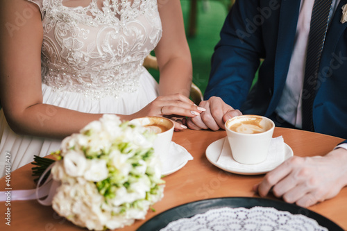 Lovers touch each other with a cup of coffee