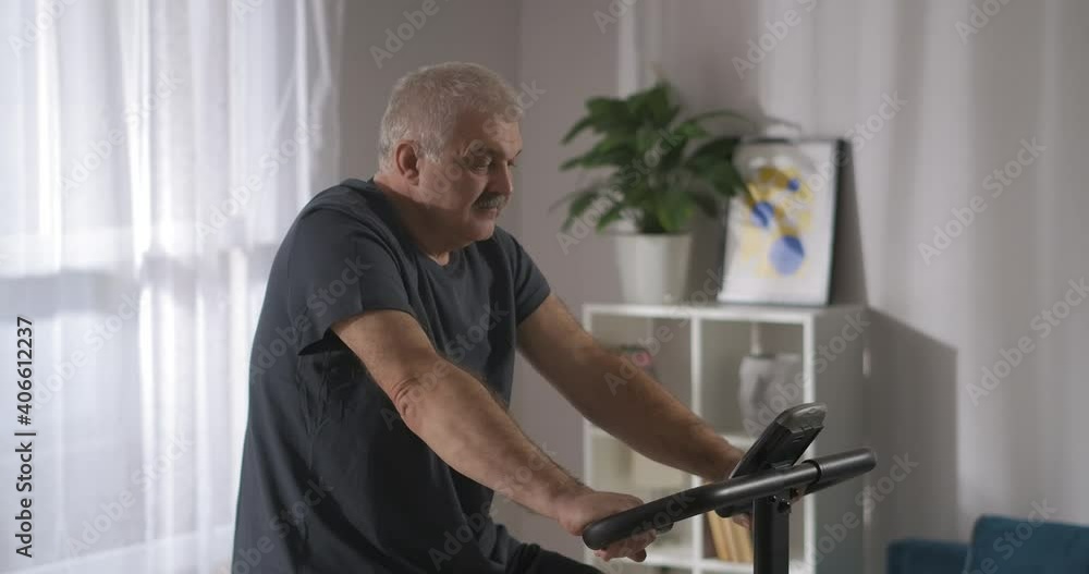 cardio training with stationary bike at home, man is spinning pedals, healthy lifestyle, workout indoors cardio training with stationary bike at home, man is spinning pedals, healthy lifestyle, workout indoors