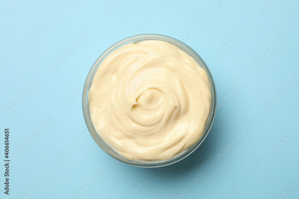 Bowl with mayonnaise sauce on blue background Bowl with mayonnaise sauce on blue background