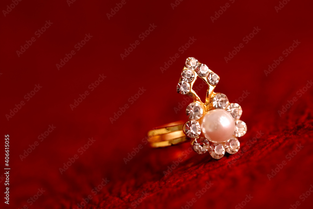 Gold ring on red textured background.