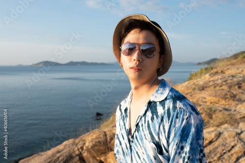 Fashion young man Wear a fashionable sunglasses and hat on seacoast   asian male at seaside.