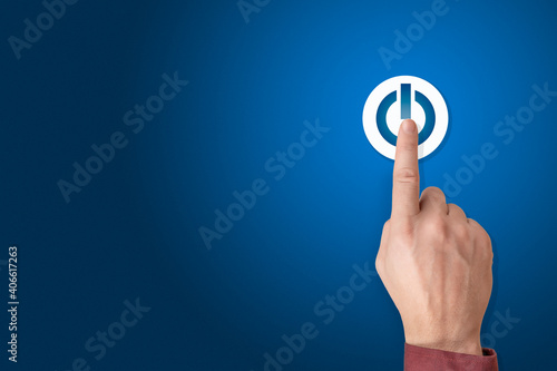 Hand of the businessman pressing power button. Start up business concept. Arm press on button on-off. Blue background, copy space photo