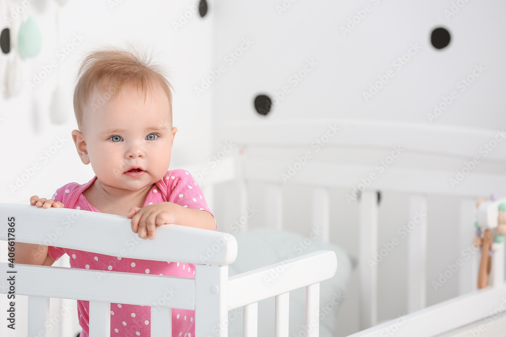 Cute little baby standing in crib at home Cute little baby standing in crib at home
