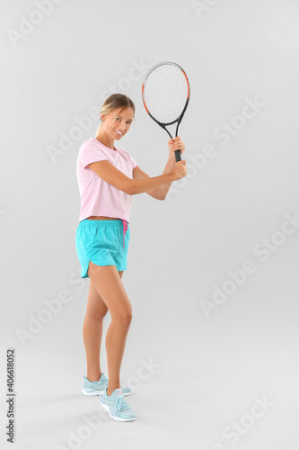 Portrait of beautiful tennis player on light background © Pixel-Shot