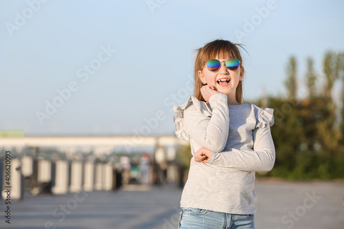 Cute little girl with stylish sunglasses outdoors