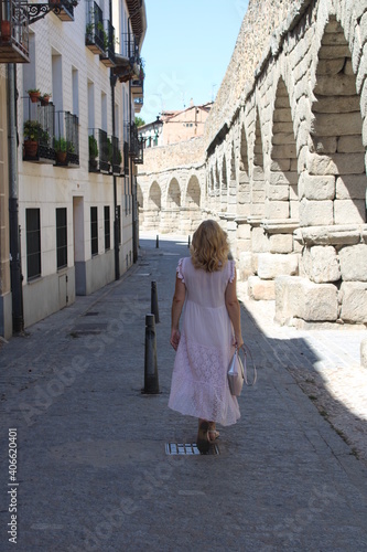 Mujer de espaldas caminando cerca del acueducto romano de Segovia