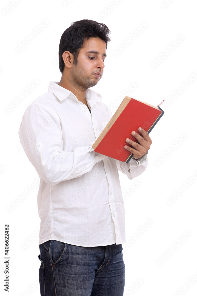 Young Indian man reading book isolated on white. Young Indian man reading book isolated on white.