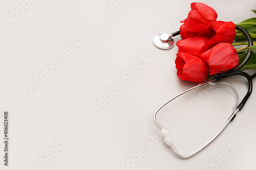 Bunch of redtulips and stethoscope on white background. National photo