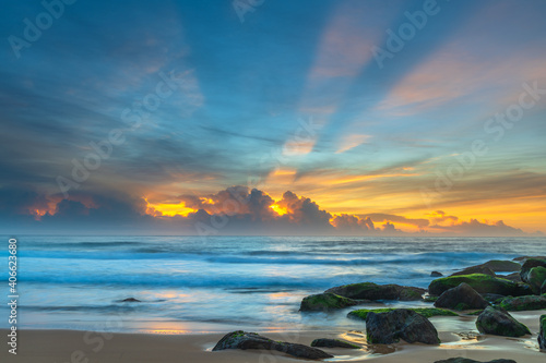 High cloud seascape with sun rays starting to show through the cloud bank on the horizon