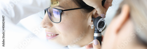 Schilderij op canvas Otolaryngologist doctor examining patients ear with otoscope in clinic