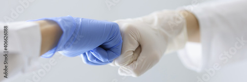 Bild auf Leinwand Doctors in rubber gloves touching their fists in clinic close-up