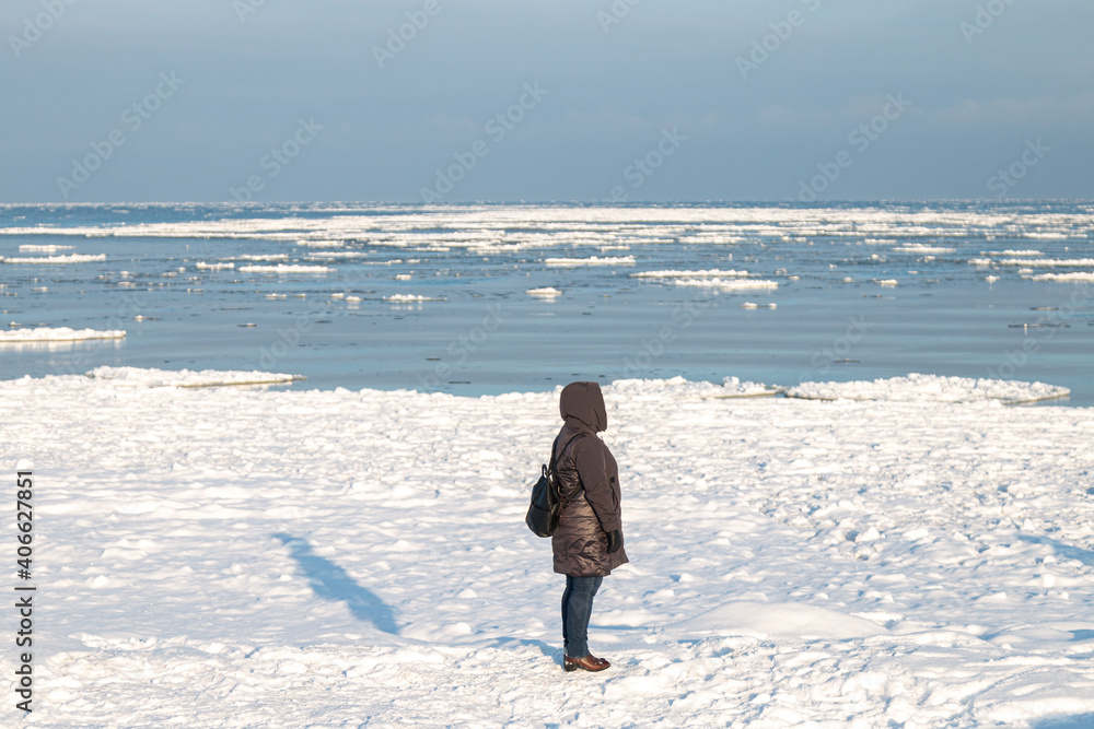 women in winter time near the frozen and snowy sea
