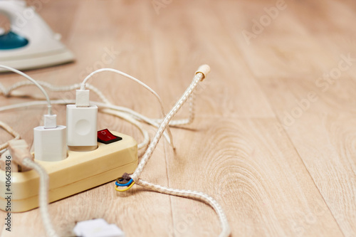 The photo shows the extension cord lying on the floor with a large current consumption. the concept of high energy consumption.