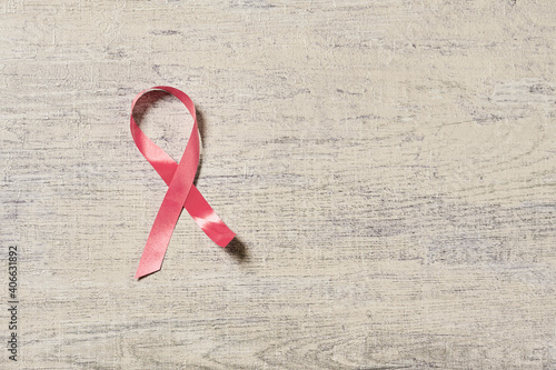 A pink cancer awarness ribbon on wooden desk photo