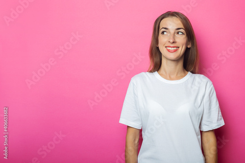 Young woman in a white t-shirt looks to the side on a pink background. Banner